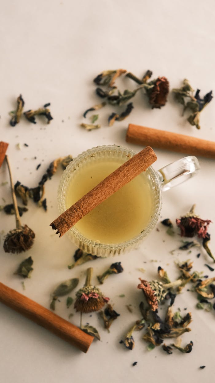 A warm cup of herbal tea with cinnamon sticks and dried flowers, perfect for relaxation.